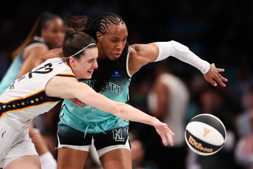 Caitlin Clark of the Indiana Fever and Kayla Thornton of the New York Liberty fight for control of the ball during the first half at Barclays Center...