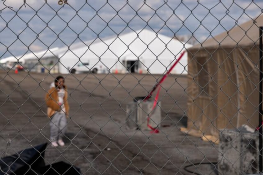 Fencing surrounds tent shelters for newly arrived migrants at a former airfield located in a remote part of New York's Brooklyn neighborhood. The 2,000-bed shelter opened in November after hotels and other city shelters ran out of space