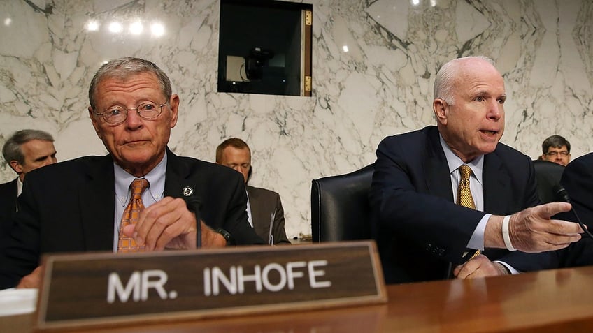 Late Sen. John McCain, R-Ariz., questions Retired U.S. Army Gen. David Petraeus while Sen. James Inhofe listens, during a Senate Armed Services Committee hearing on Capitol Hill in September 2015.