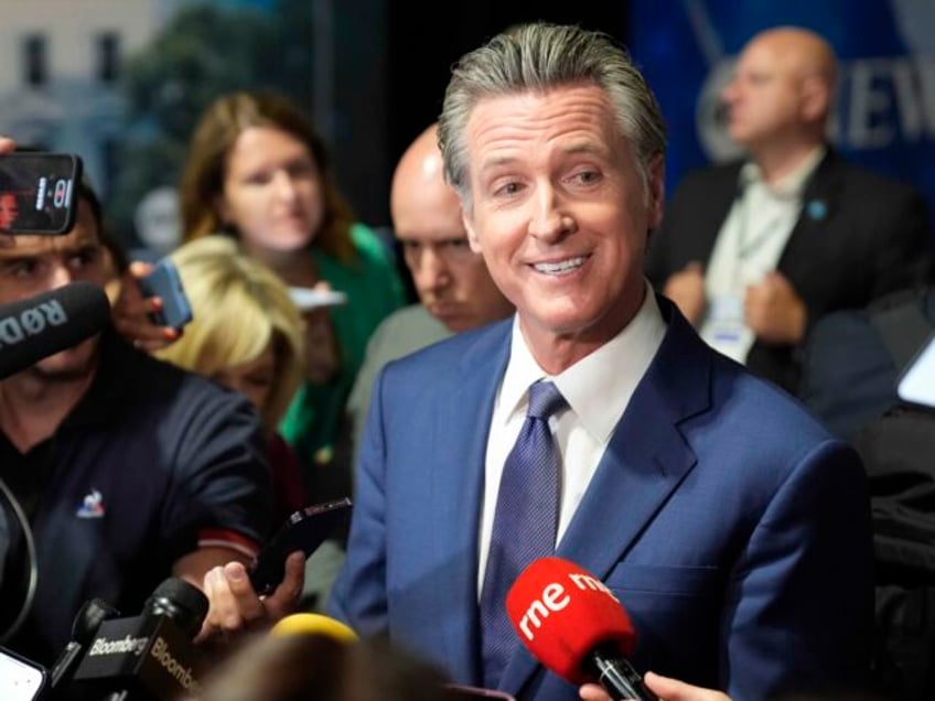 California Gov. Gavin Newsom speaks to reporters in the spin room before a presidential de