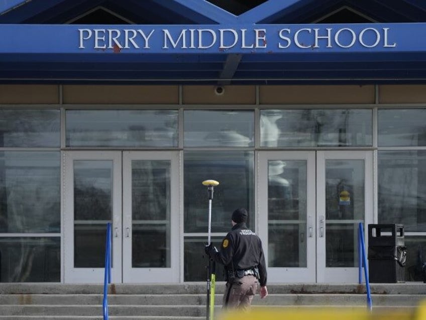 A law enforcement official walks past the Perry Middle School entrance following a shooting at the nearby Perry High School, Thursday, Jan. 4, 2024, in Perry, Iowa. Multiple people were shot inside the school early Thursday as students prepared to start their first day of classes after their annual winter …