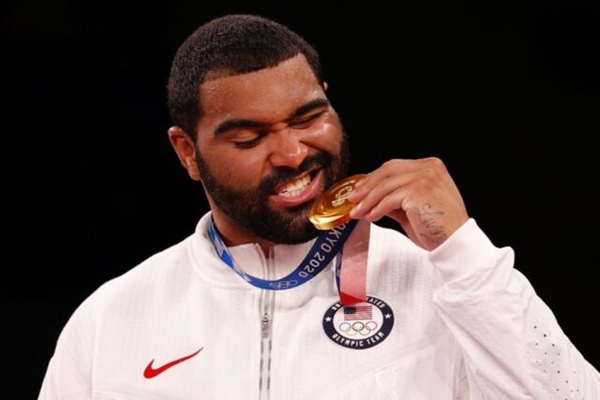 Gable Steveson, posing with his Tokyo Olympic gold medal, has signed a three-year NFL deal