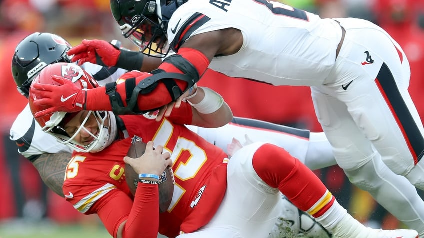 Kansas City Chiefs quarterback Patrick Mahomes, #15, is tackled by Azeez Al-Shaair, #0 of the Houston Texans, during the first quarter in the AFC Divisional Playoff at GEHA Field at Arrowhead Stadium on Jan. 18, 2025 in Kansas City, Missouri.