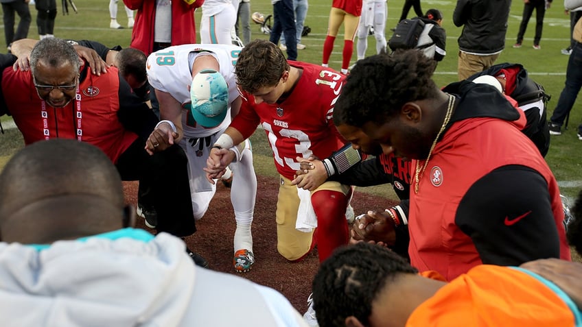 Brock Purdy leads a prayer circle