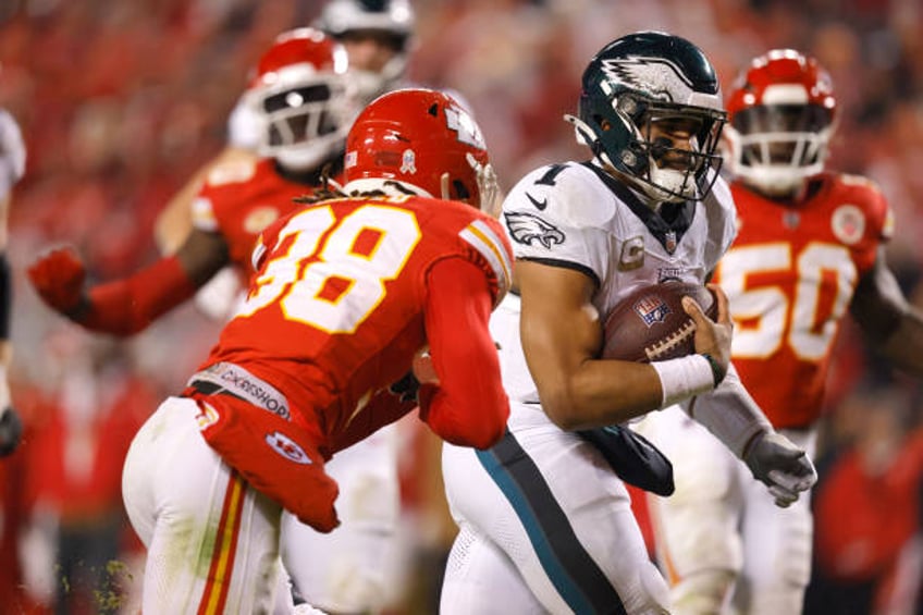 Jalen Hurts of the Philadelphia Eagles scambles past L'Jarius Sneed of the Kansas City Chiefs for a touchdown in the second half at GEHA Field at...