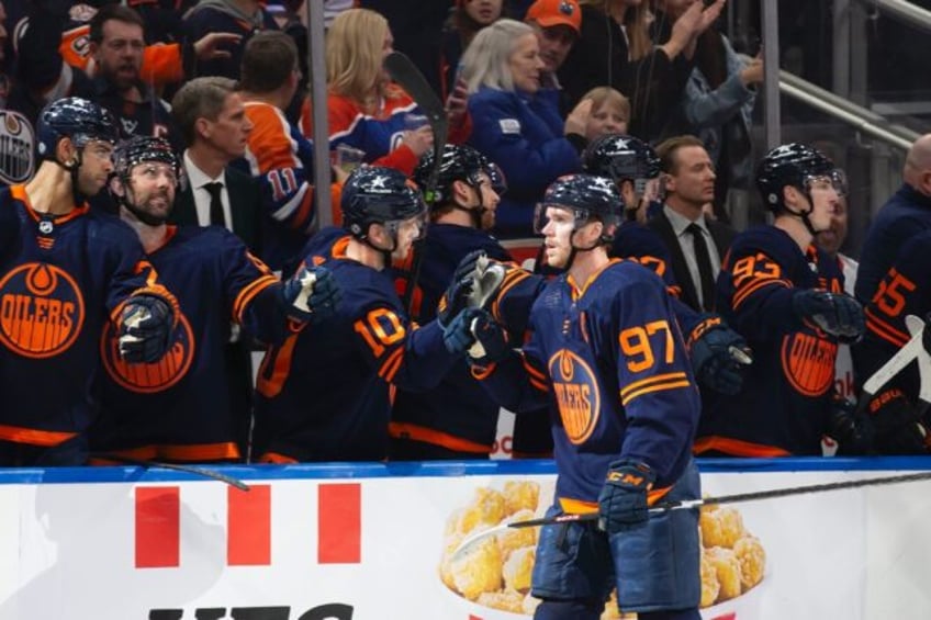 Connor McDavid celebrates a goal with teammates on the Edmonton Oilers, who won their 16th consecutive game to move within one of matching the longest win streak in NHL history