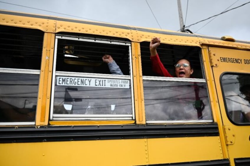 Released Nicaraguan political prisoners wave from a bus after arriving at the Guatemala Ci