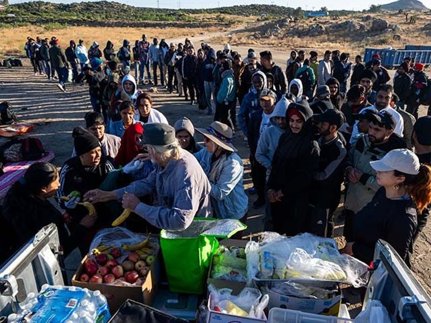 Volunteers distribute food to migrants who crossed into the U.S. from Mexico on June 14, 2