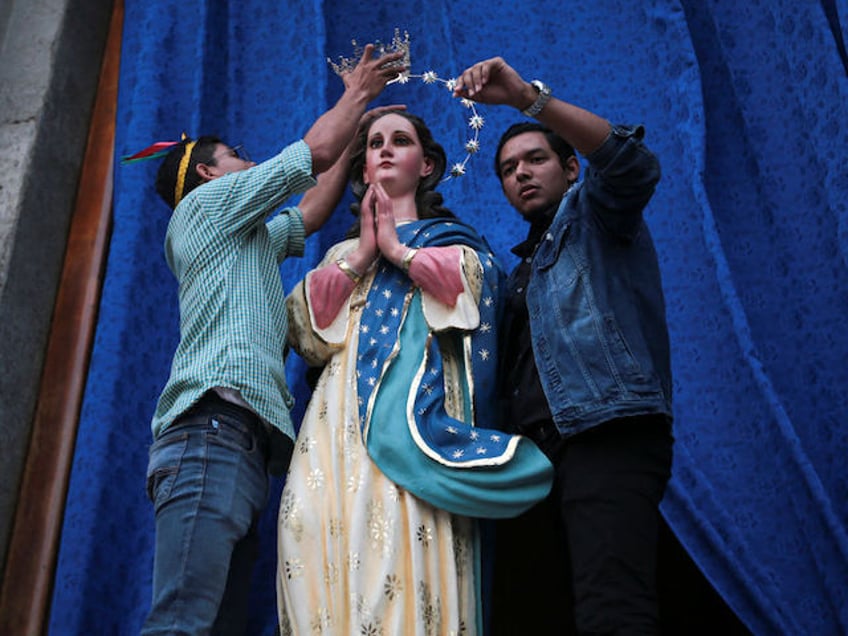 People decorate a sculpture of the Virgin Maria de la Concepcion during celebrations marking "La Griteria" at the Metropolitan Cathedral in Managua, on December 7, 2023. (Photo by AFP)