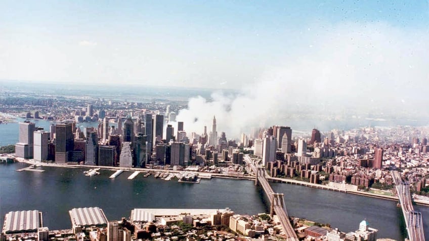 New York City Office of Emergency Management shows an aerial view from Brooklyn over the East River to Lower Manhattan where smoke rises from the ruins of the World Trade Center 15 September 2001. 