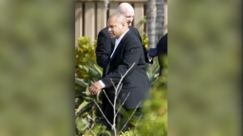 Man in tuxedo walking outside in a garden