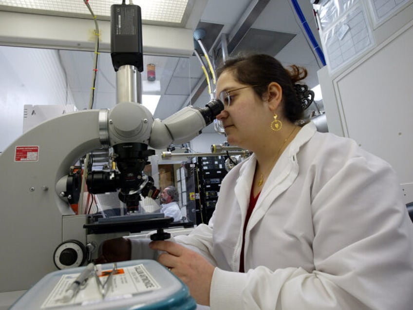 Technologist Amal Ikhlassi (cq) looks through her microscope while working at Rockwell Sci