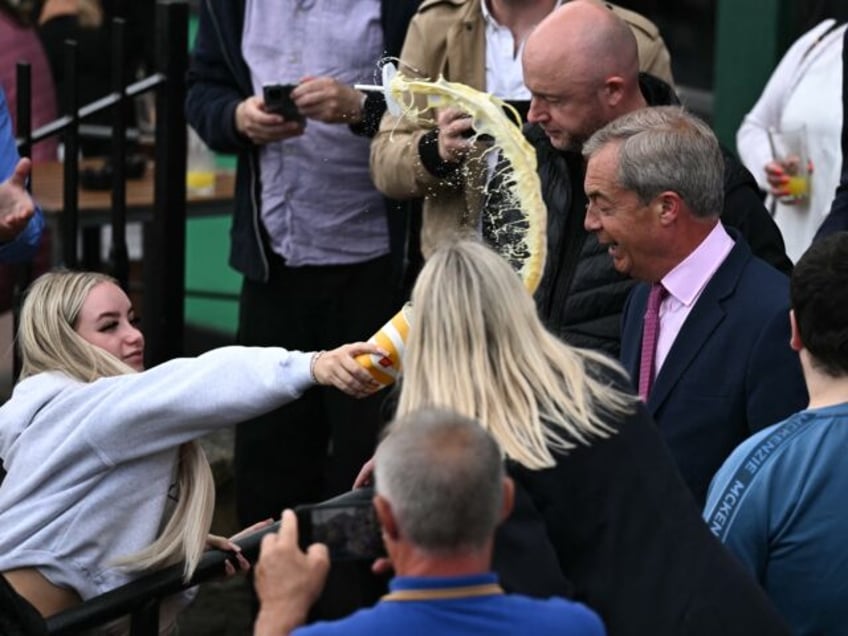 A person throws a milkshake drink in the face of newly appointed leader of Britain's right