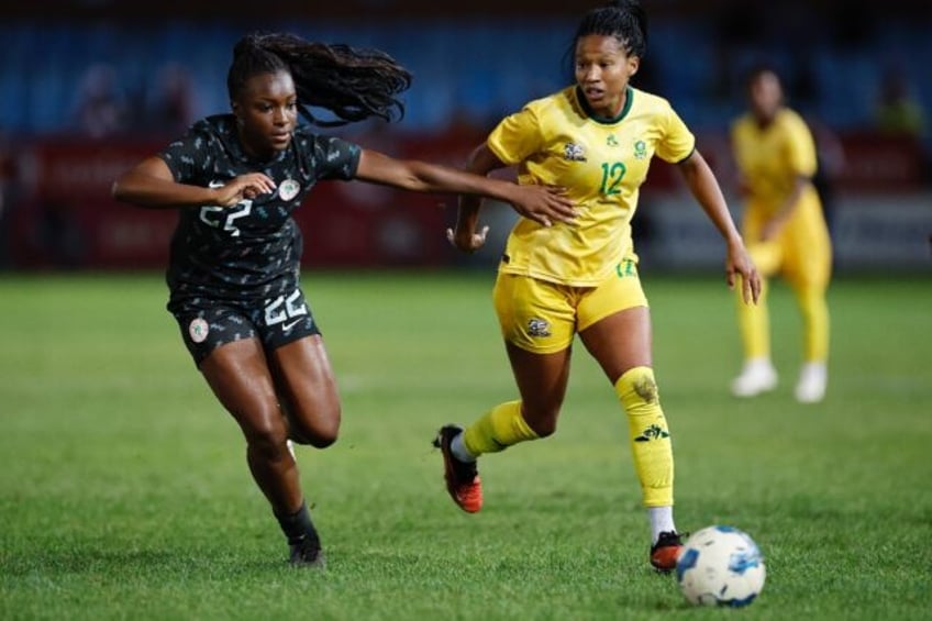 Michele Alozie (L) of Nigeria and Jermaine Seoposenwe of South Africa in action during a 2