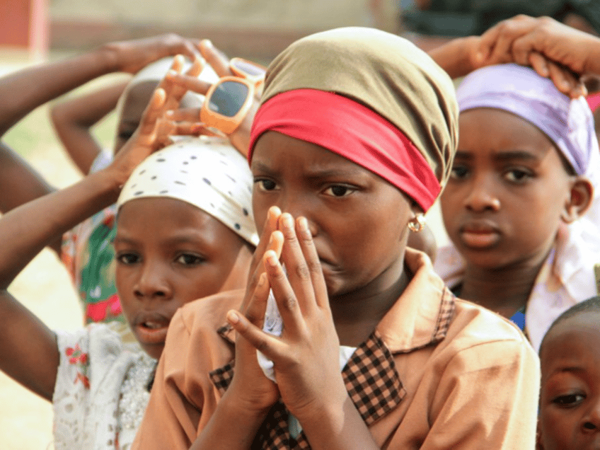 Children pray during as Christian community members take part in a protest against the kil