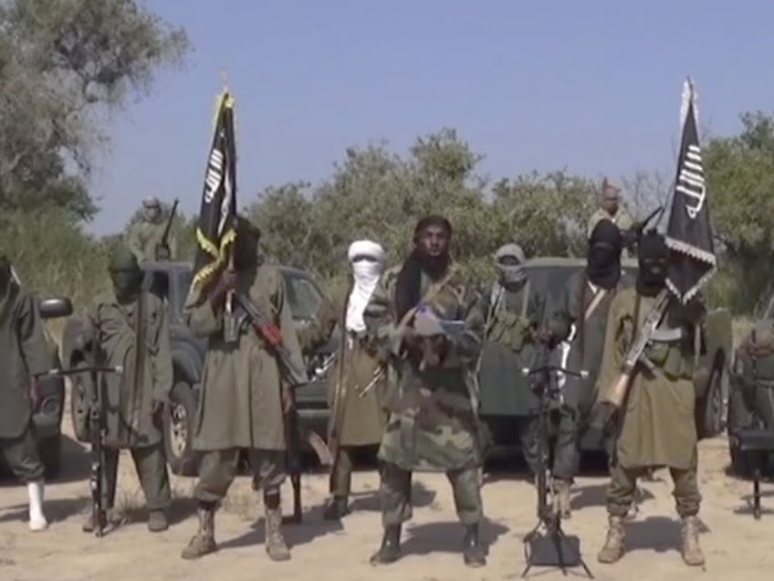 This Friday Oct. 31, 2014 image taken from video by Nigeria's Boko Haram terrorist network, the leader of Nigeria's Islamic extremist group Boko Haram, center, has denied agreeing to any cease-fire with the government and said Friday more than 200 kidnapped schoolgirls all have converted to Islam and been married off. (AP Photo)