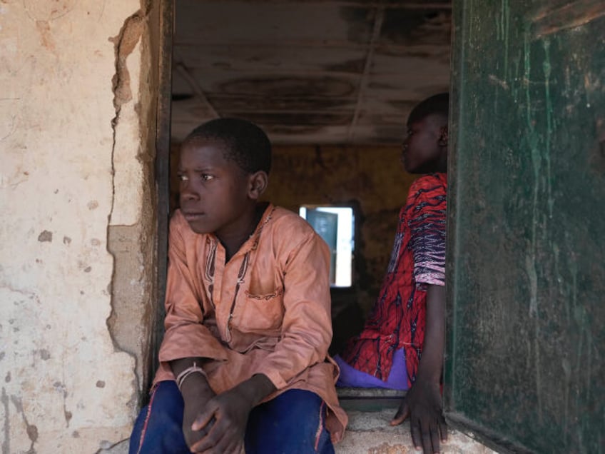 A child sits on a window of a class room at the LEA Primary and Secondary School Kuriga in