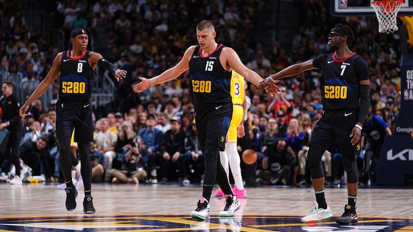 Nikola Jokic high fives teammates