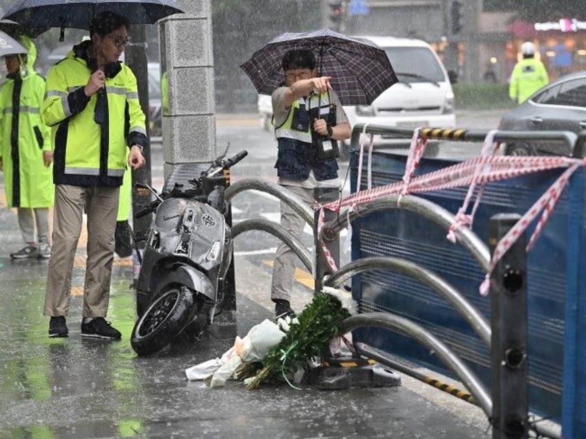 Policemen and Korea Road Traffic Authority officials investigate at the site of a car acci