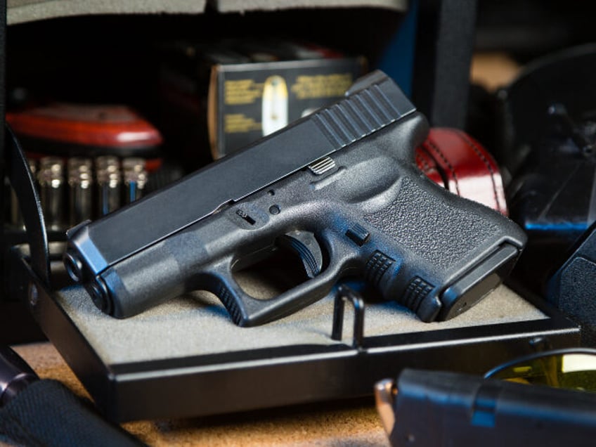 An automatic pistol handgun with a gun safe and shooting equipment.