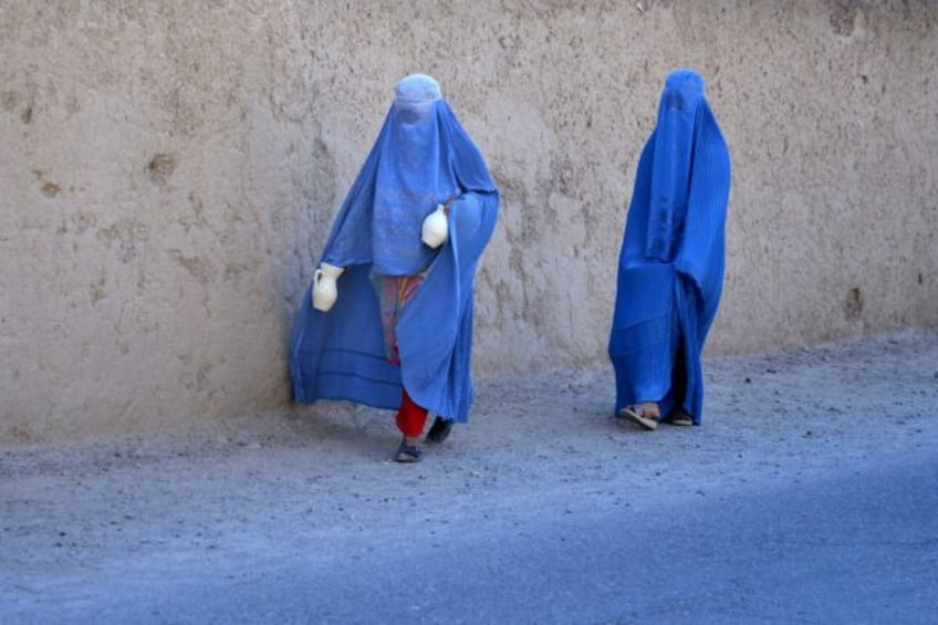 Afghan women walk along a road in Arghandab district of Kandahar province on May 27, 2024