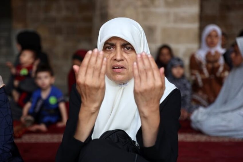 a Palestinian woman performs the Eid al-Adha morning prayer in the courtyard of Gaza City'