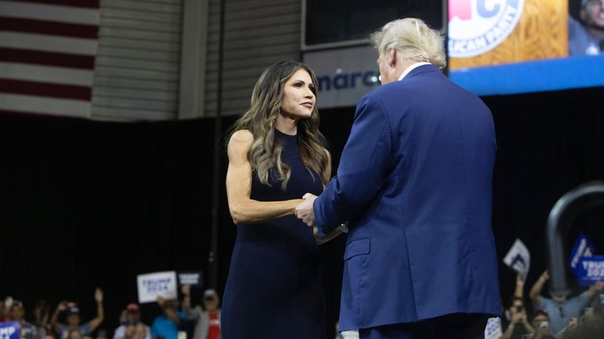 Kristi Noem with Donald Trump on stage