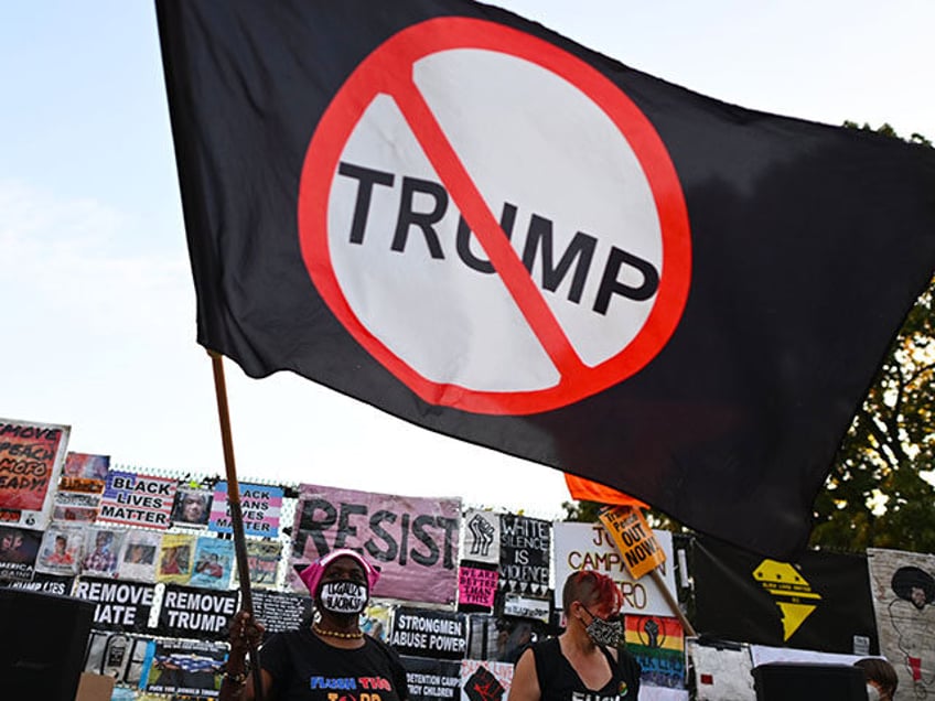 Protestors wave an anti-Trump flag at Black Lives Matter Plaza, near the White House, in W