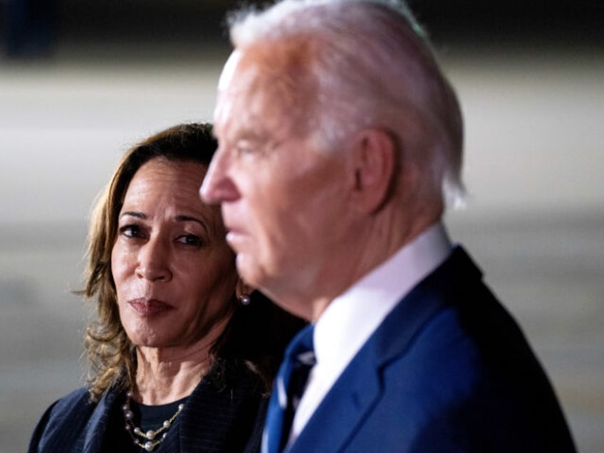 US Vice President Kamala Harris, left, watches as President Joe Biden speaks to members of