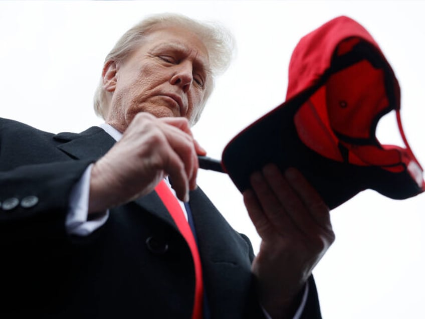 LONDONDERRY, NEW HAMPSHIRE - JANUARY 23: Republican presidential candidate, former U.S. President Donald Trump autographs hats while visiting with supporters outside the polling site at Londonderry High School on January 23, 2024 in Londonderry, New Hampshire. With Florida Gov. Ron DeSantis having dropped out of the race two days earlier, …