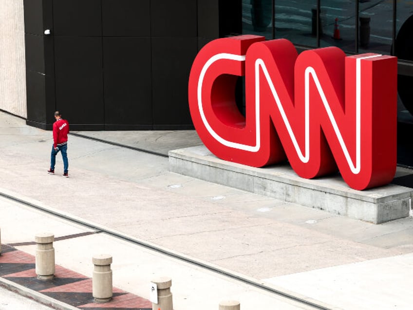 People walk by the world headquarters for CNN on March 15, 2022 in Atlanta, Georgia. Last