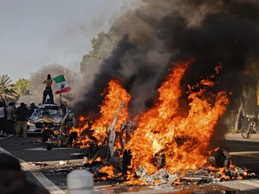 LOS ANGELES, CALIFORNIA - JUNE 8: Several cars burn on North Los Angeles street during cla