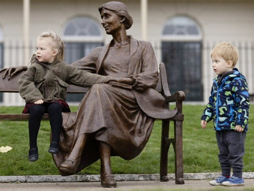 Children play on a newly unveiled statue of Virginia Woolf, which sits alongside the River