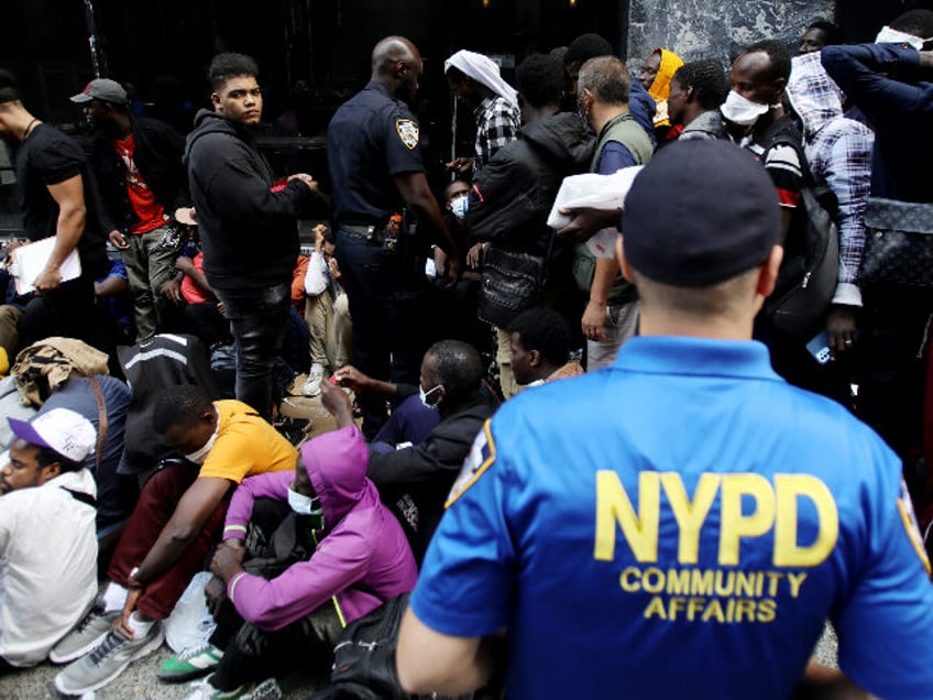 NEW YORK, NEW YORK - AUGUST 02: Migrants wait outside the Roosevelt Hotel hoping for a pla