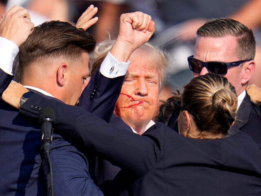 Republican presidential candidate former President Donald Trump is helped off the stage by