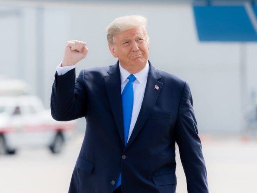 President Donald J. Trump gestures with a fist pump as he walks across the tarmac upon his