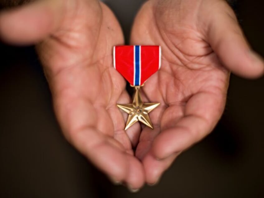 SOUTHPORT, ME - MAY 28: The Bronze Star lies cradled in the hands of U.S. Army vet Dennis