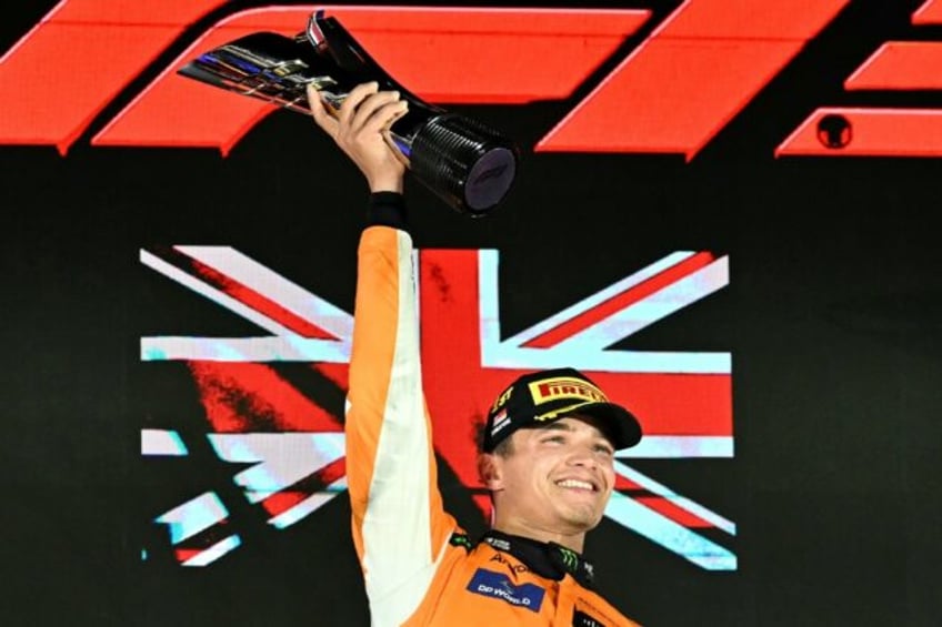 McLaren's British driver Lando Norris (C) celebrates winning on the podium after the Formu