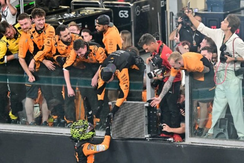 Lando Norris celebrates with the McLaren crew after winning the Abu Dhabi Grand Prix to se