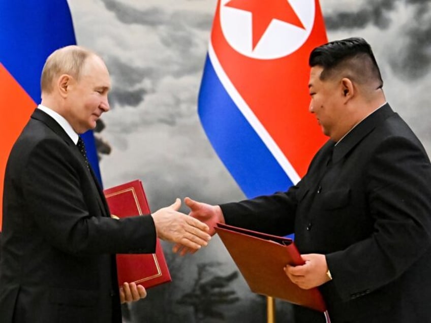 Russian President Vladimir Putin, left, and North Korea's leader Kim Jong Un exchange docu