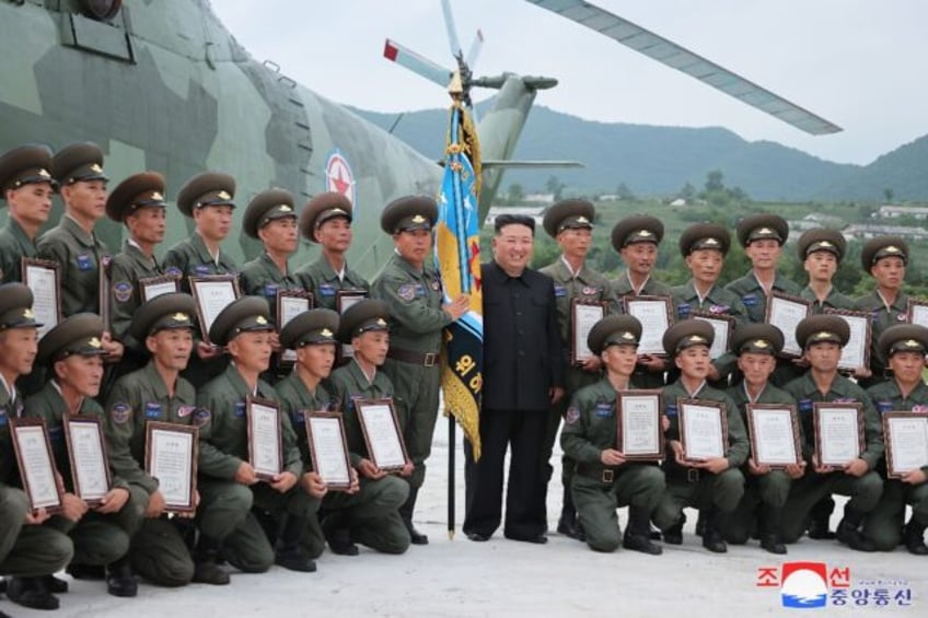 North Korean leader Kim Jong Un (C) posing with members of a military helicopter unit Pyon