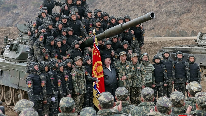 Kim, dozens of soldiers posing for a picture