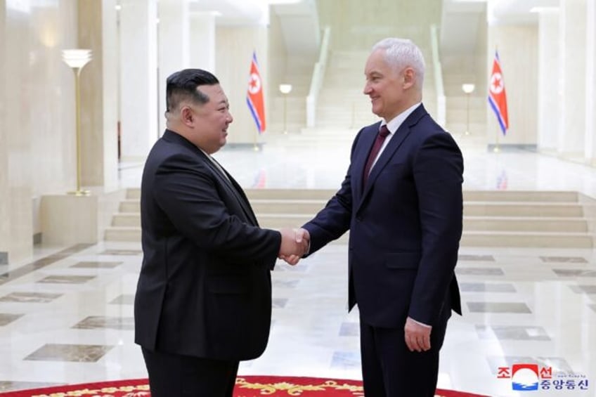 North Korean leader Kim Jong Un (L) greets Russian defence chief Andrei Belousov in Pyongy