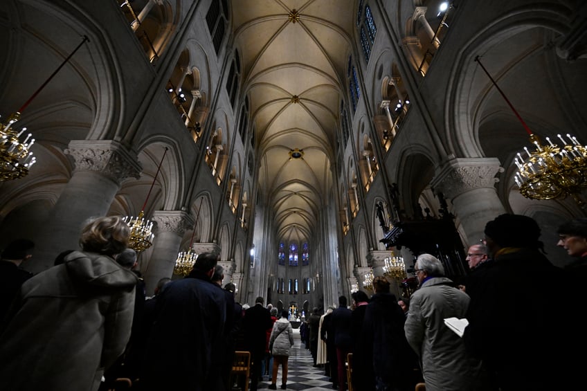 Devotees attend prayers lead by Archbishop of Paris Laurent Ulrich for the consecration of the main altar, designed by French artist and designer Guillaume Bardet which replaces the old one that was destroyed in 2019, during a mass at the Notre-Dame de Paris cathedral, in Paris on December 8, 2024. Newly restored Notre Dame cathedral is set to hold its first service for the public on December 8, 2024 after a historic re-opening ceremony that saw firefighters, builders and artists celebrated for their work saving the 12th-century masterpiece. The beloved Paris monument nearly burned down in 2019, but has been renovated inside and fitted with a new roof and spire during a frenzied reconstruction effort since then. (Photo by JULIEN DE ROSA / AFP) / RESTRICTED TO EDITORIAL USE - MANDATORY MENTION OF THE ARTIST UPON PUBLICATION - TO ILLUSTRATE THE EVENT AS SPECIFIED IN THE CAPTION (Photo by JULIEN DE ROSA/AFP via Getty Images)