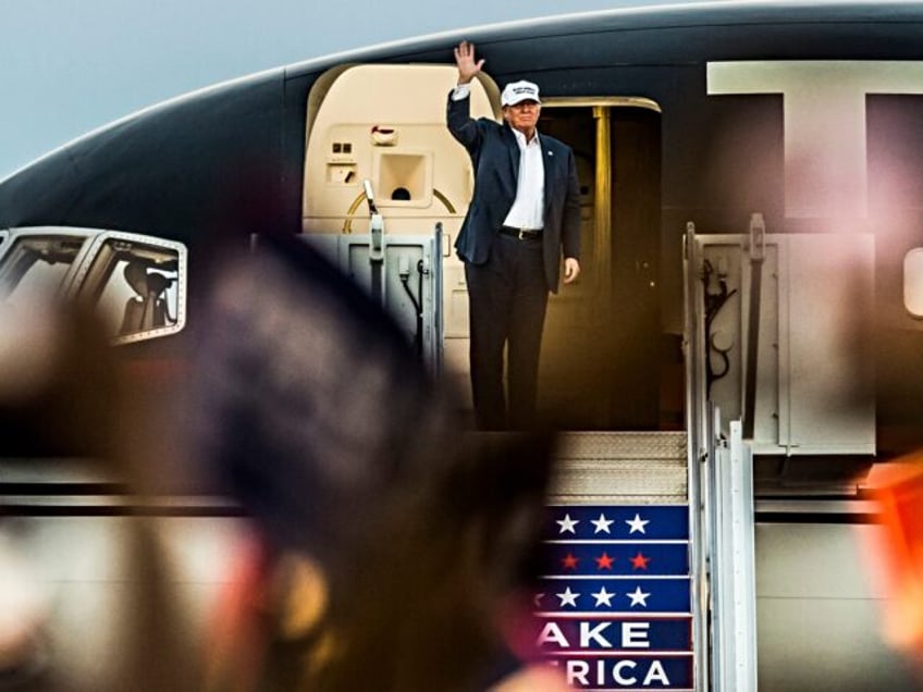 Republican presidential candidate Donald Trump waves from his plane before speaking at the