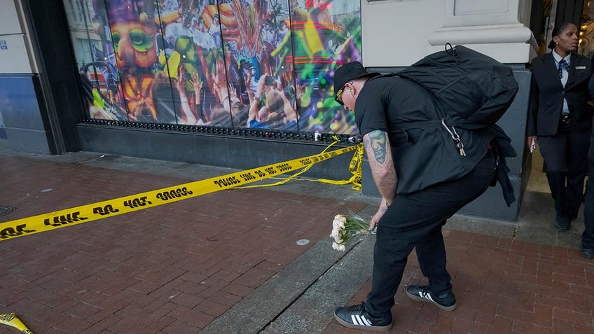 Man leaves flowers on Canal Street