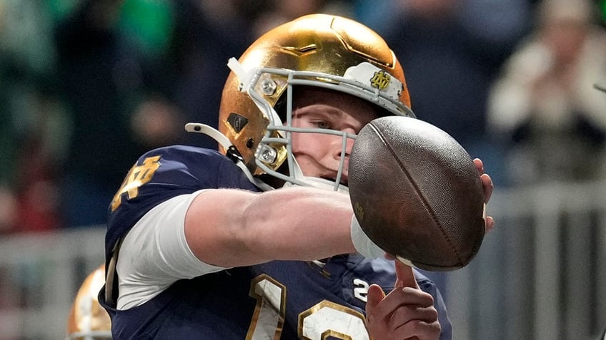 Riley Leonard points to his arm band