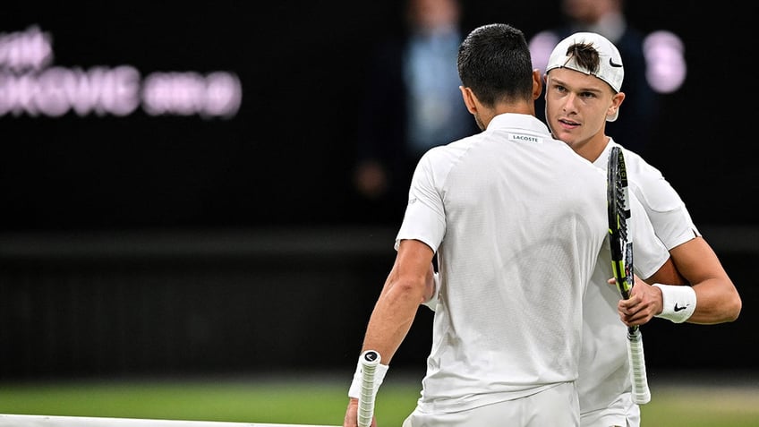 Novak Djokovic hugs Holger Rune