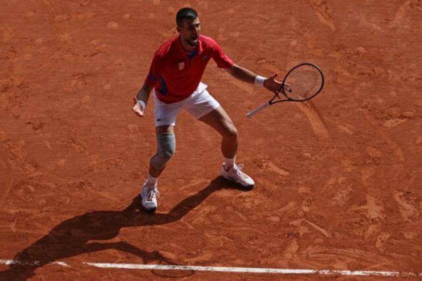 Serbia's Novak Djokovic celebrates beating Carlos Alcaraz to win Olympic gold