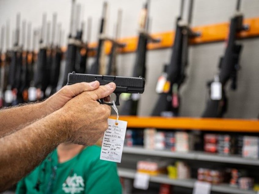A customer holds a handgun for sale at Knob Creek Gun Range in West Point, Kentucky, U.S., on Thursday, July 22, 2021. Firearm sales have reached a near-record pace of well over 1 million a month, according to Small Arms Analytics & Forecasting. (Jon Cherry/Bloomberg via Getty)